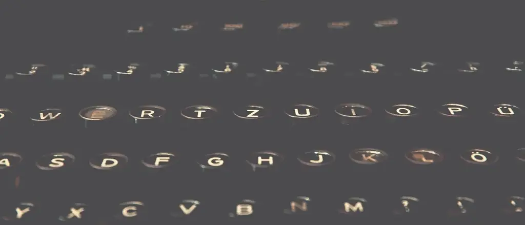 Three rows of typewriter keys in low light, the middle row nearest the camera